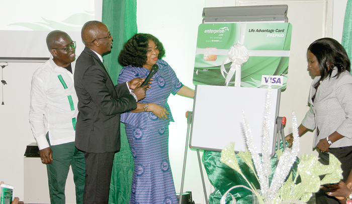  Ms Lydia Bawa (2nd right), the Insurance Commissioner, being supported by Mrs Jaqueline Benyi (right), Mr Keli Gadzekpo, Group CEO (2nd left), and Mr Fiifi Kwakye, Board Chairman, to unveil one of the products 